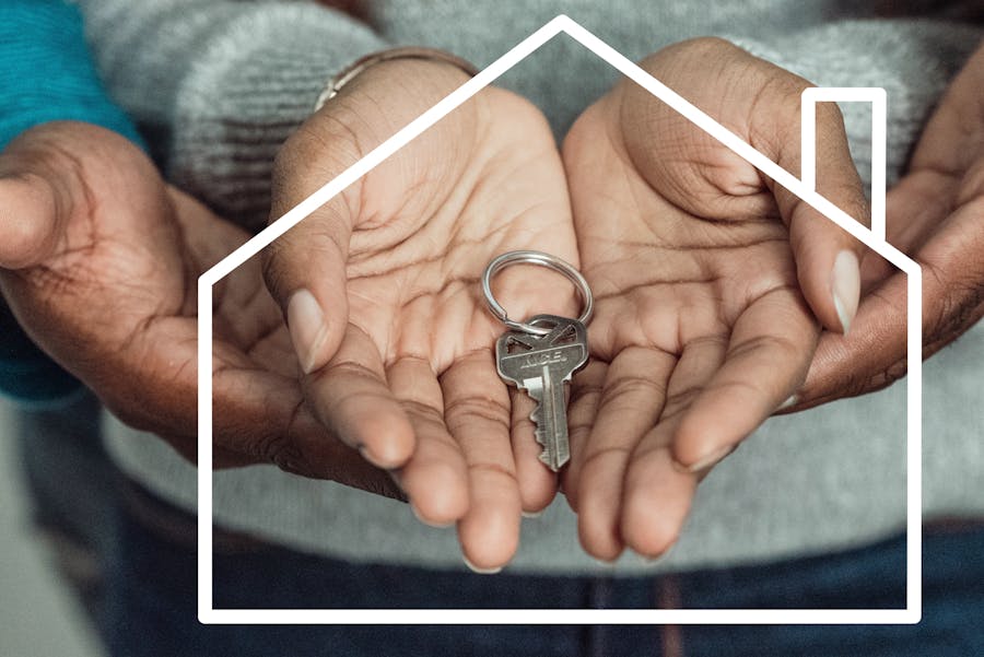 hands holding a house key